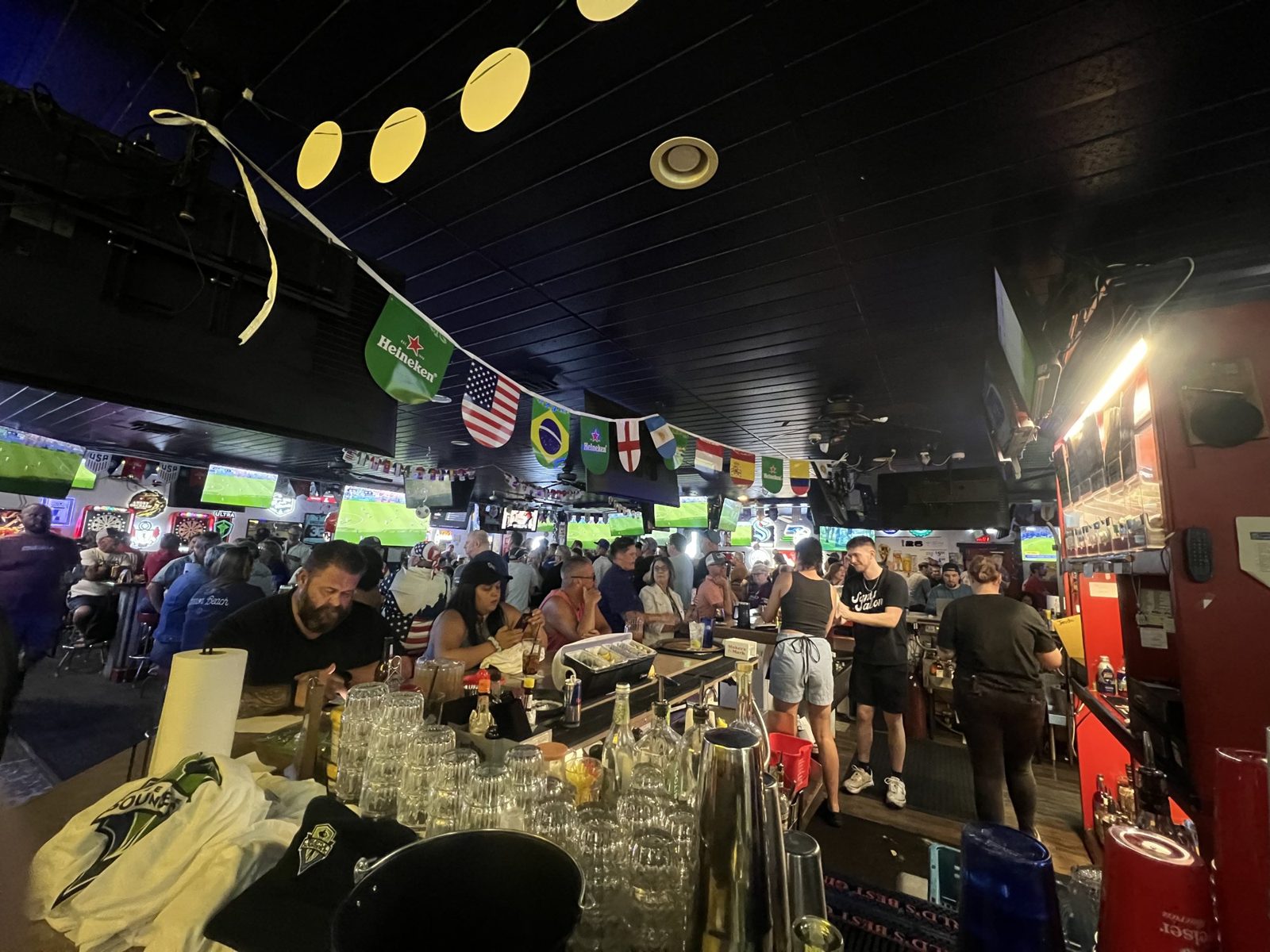 Packed house watching soccer under international flags at Sam's Saloon in Kennewick, WA